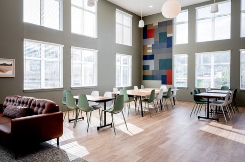 a dining room with tables and chairs and large windows