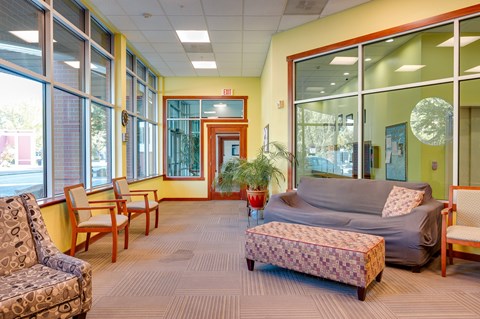 A living room with a grey couch and a wooden chair.