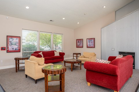 A living room with a red couch and a fireplace.