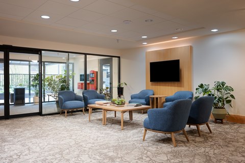 A conference room with blue chairs and a wooden table.