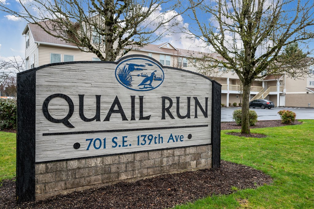 a sign that says quail run in front of a building