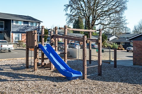 A playground with a blue slide and wooden structure.
