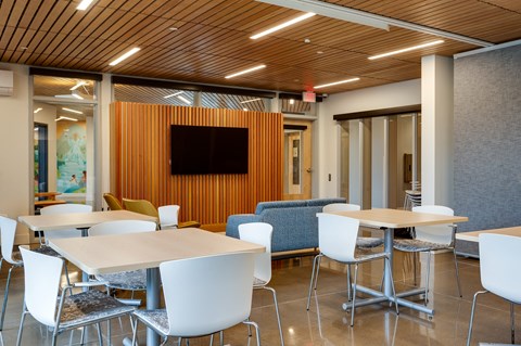 a conference room with tables and chairs and a television