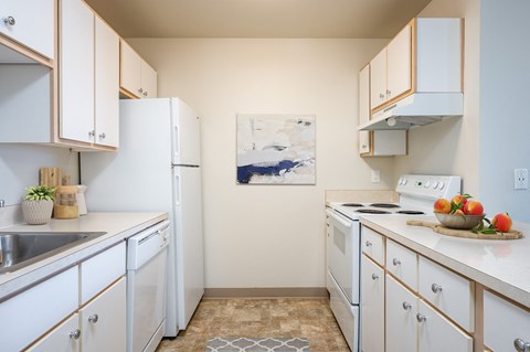 a kitchen with white appliances and counters and white cabinets