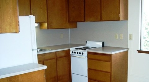 A white stove and oven in a kitchen with wooden cabinets.