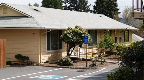 A small building with a parking spot in front.