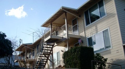 A two-story house with a balcony and a staircase leading to the second floor.