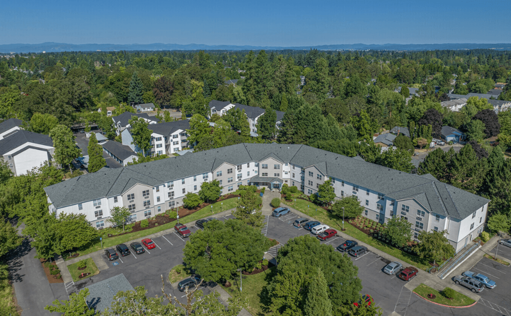 A large white building with a parking lot in front of it.