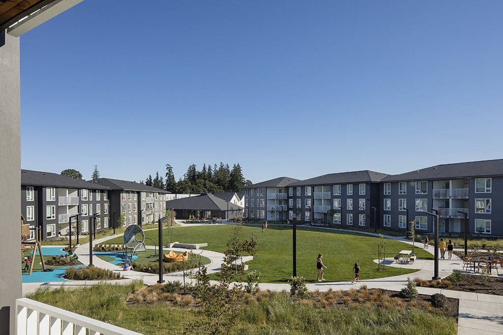 A view of apartment buildings with a pool and playground.