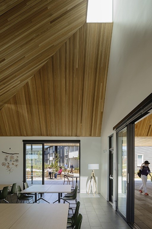 A room with a wooden ceiling and a table with chairs.