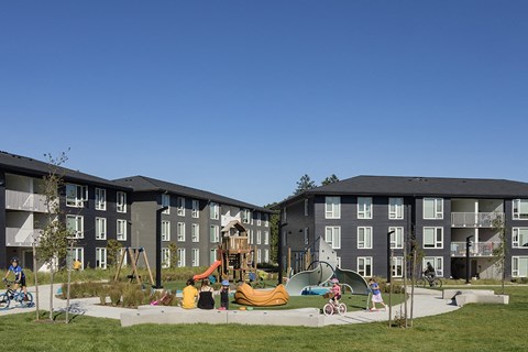 A playground area in front of apartment buildings.