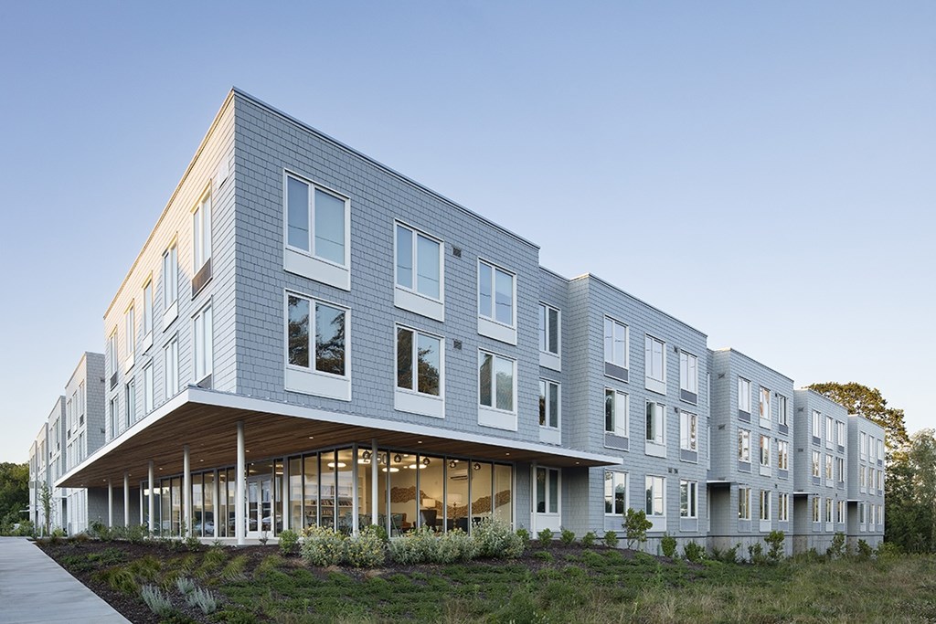 A modern building with a grey facade and large windows.