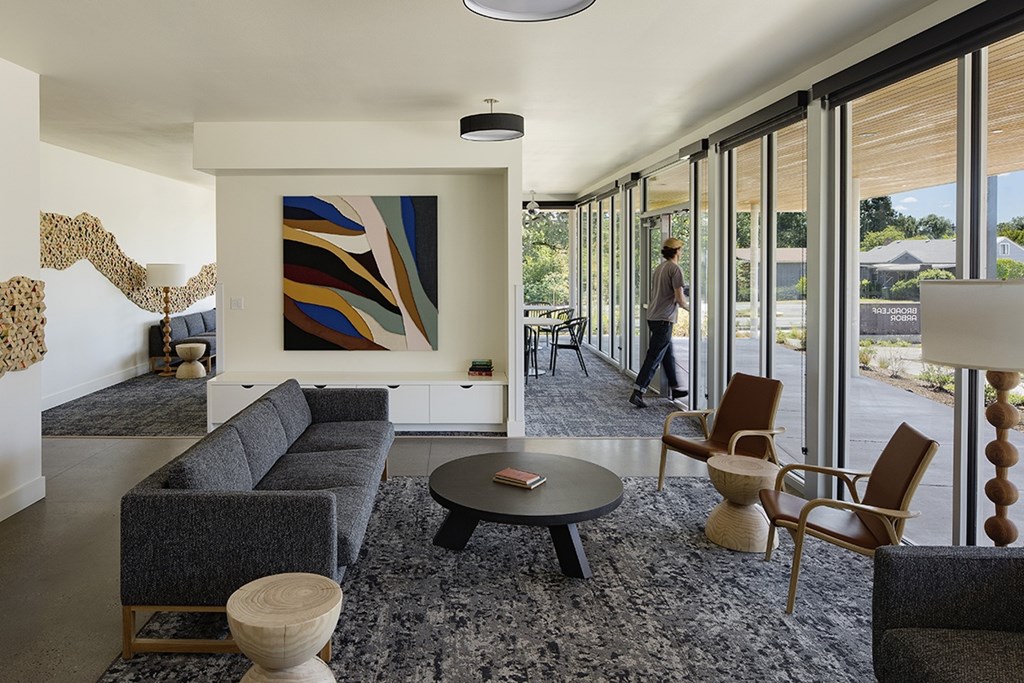 A person is standing in a room with a large painting on the wall.