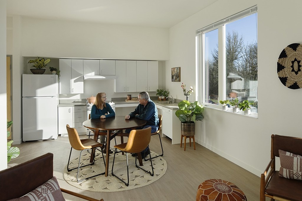 Two people sitting at a table in a brightly lit room.