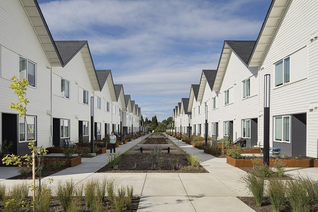 A row of white houses with a person walking in the middle.