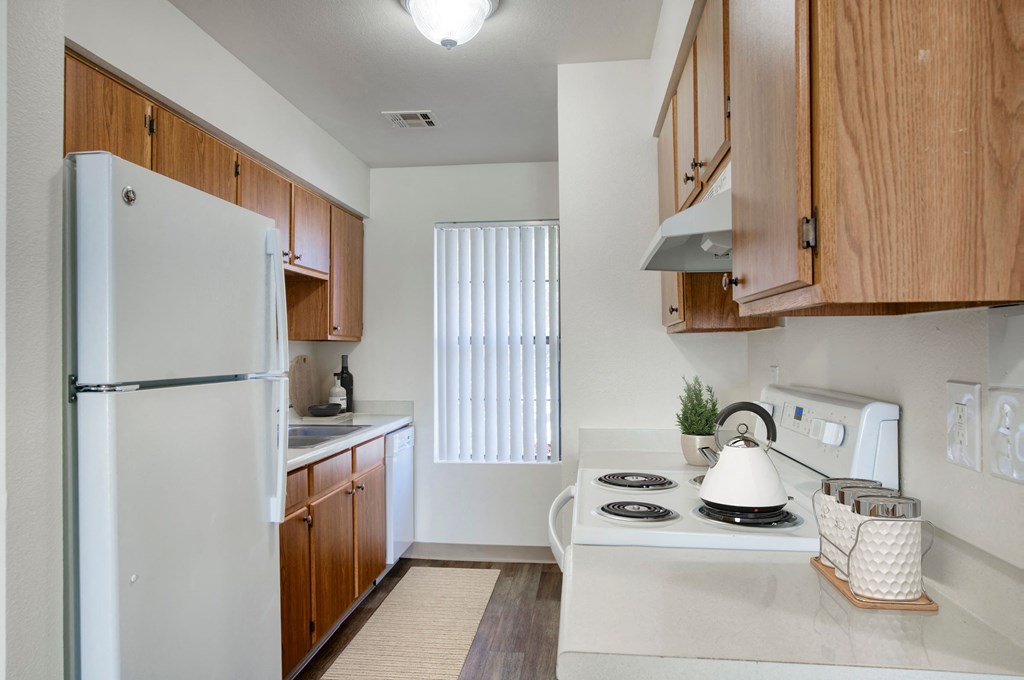 a kitchen with white appliances and wooden cabinets