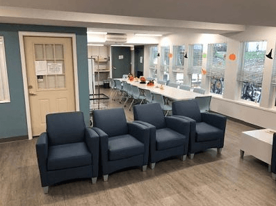 a room with blue chairs and a table and a door