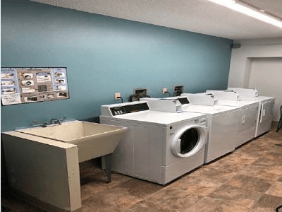 a laundry room with two washing machines and a sink