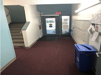 a hallway in a building with a door and stairs