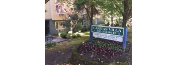 a sign for the caritas villa subdivision in front of a house