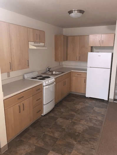 an empty kitchen with a stove and a refrigerator