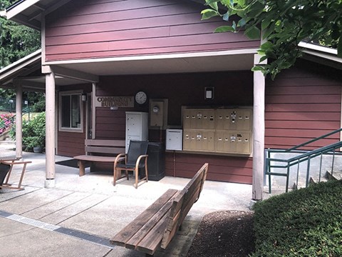 a porch in front of a red house with a wooden bench