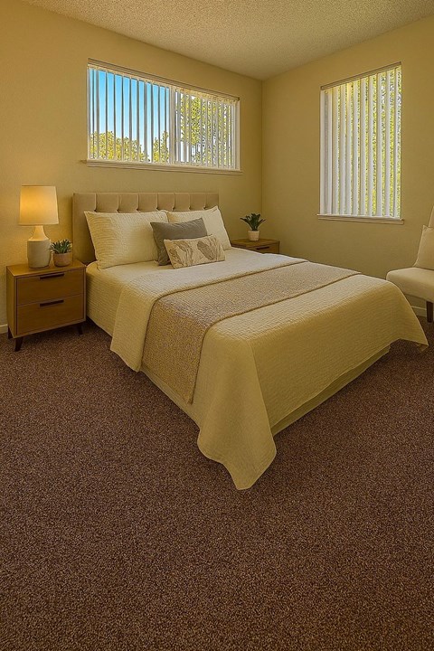 A bedroom with a bed, nightstand, and chair.