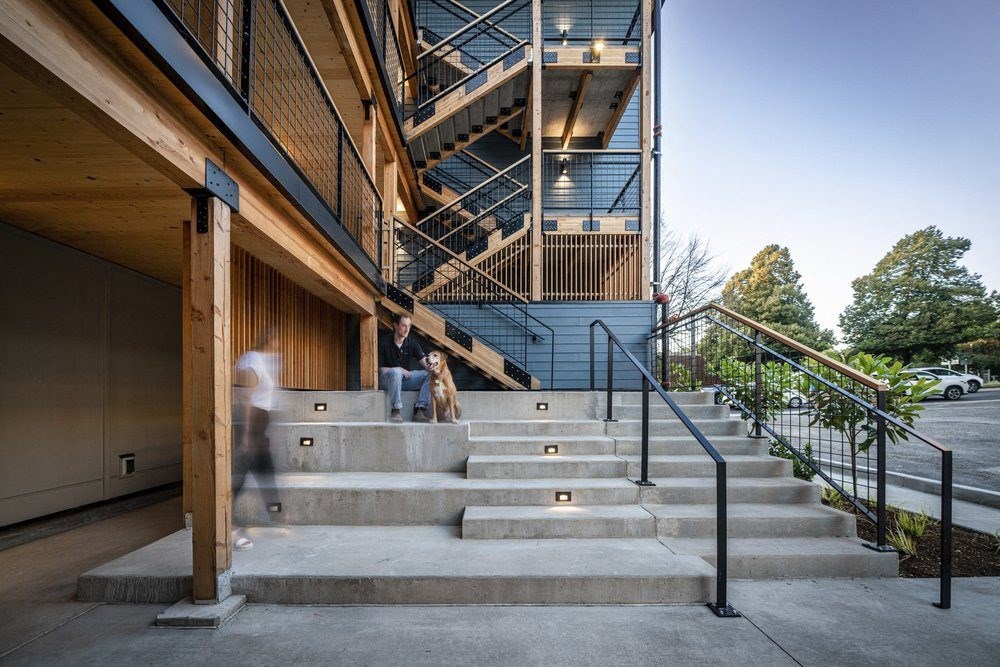 a man and a dog standing on the stairs of a building