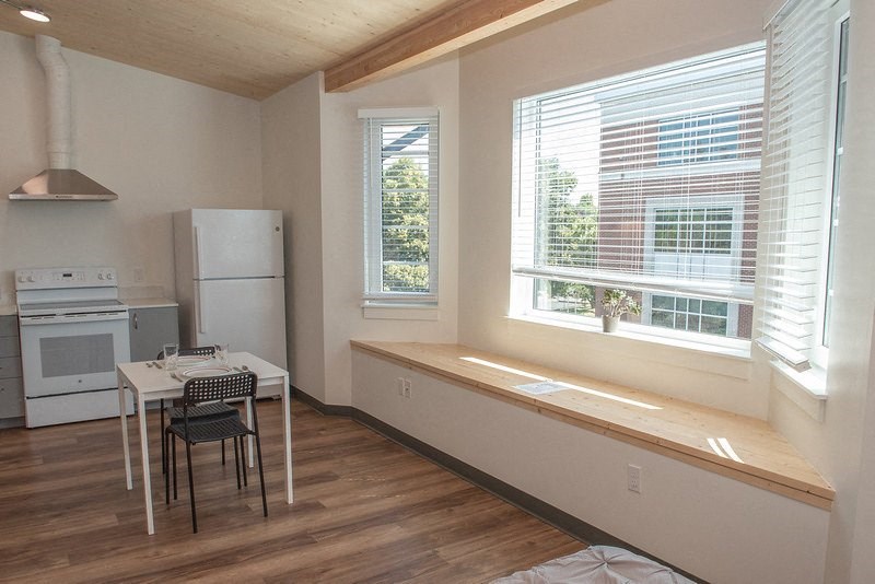 an empty kitchen with a table and a large window