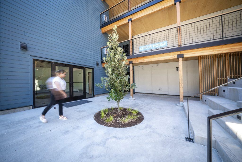 a man walks through a courtyard in front of a building