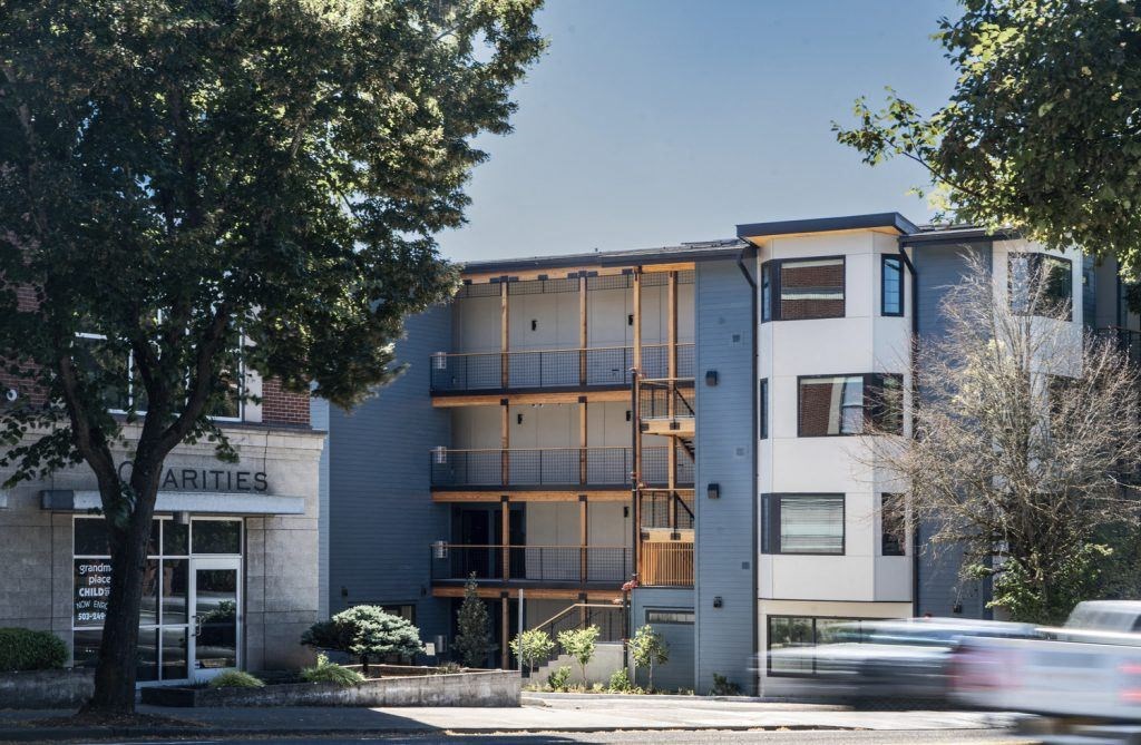 a building with a street in front of it and a tree