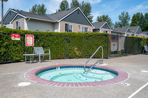 A pool surrounded by a black fence with a sign on it.