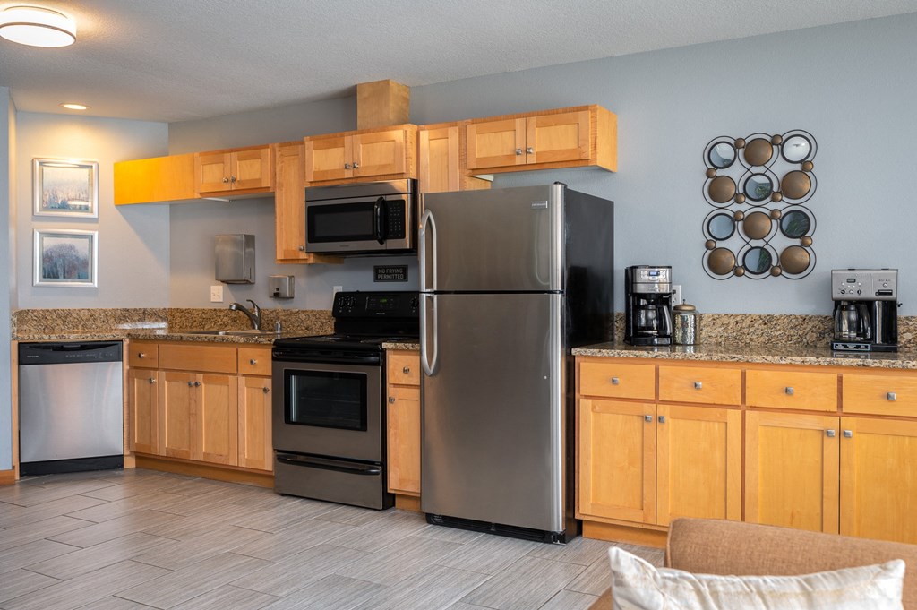 a kitchen with wood cabinets and stainless steel appliances