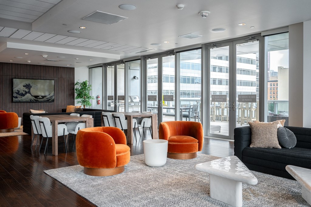 a living room with orange chairs and a table with a couch