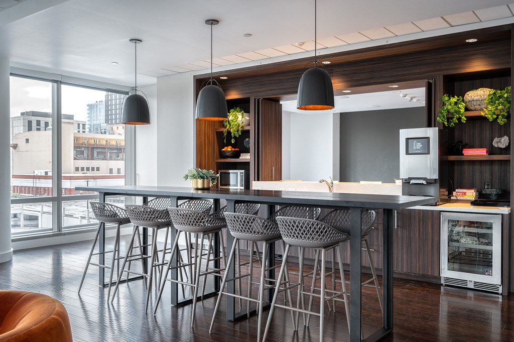 a kitchen with a large island with bar stools and chairs