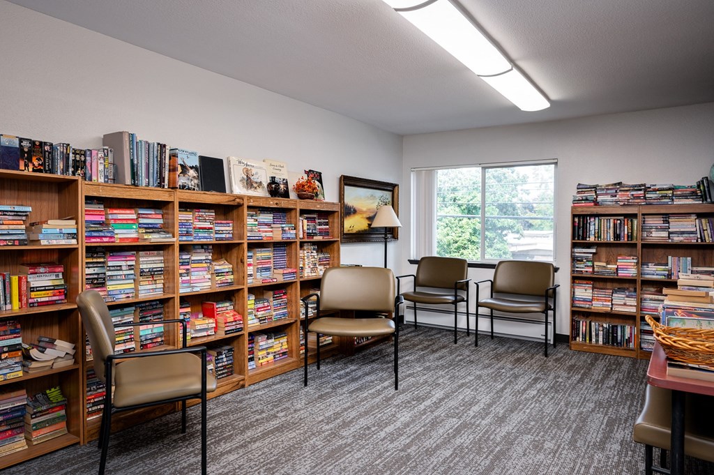 a library with chairs and bookshelves filled with books