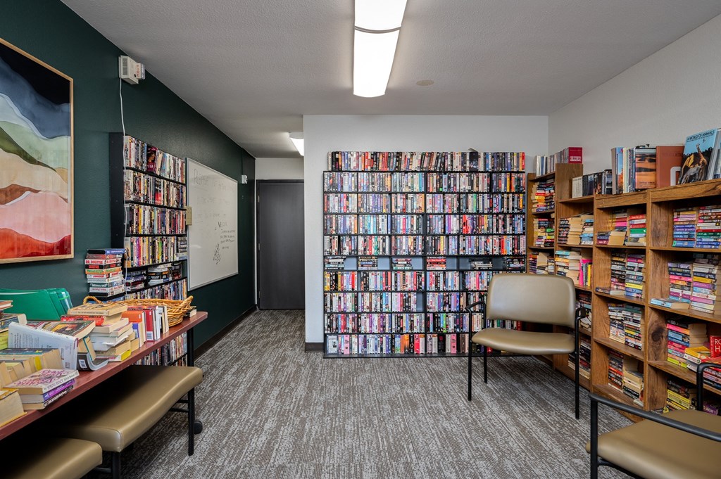a library filled with books and a table with chairs
