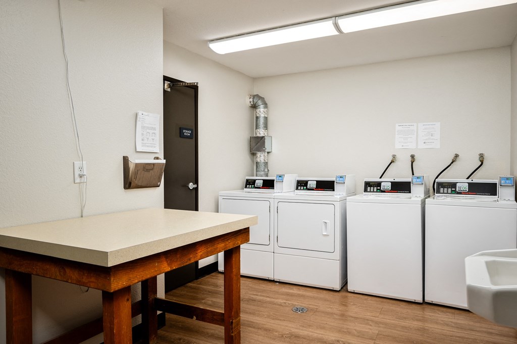 a laundry room with washers and dryers and a table