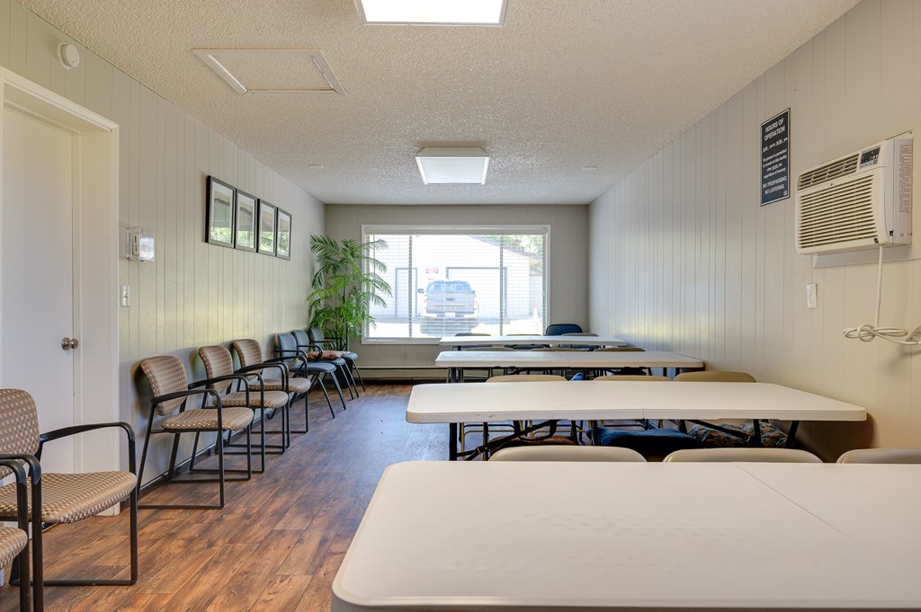 A room with a long table and chairs.
