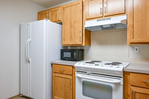 a kitchen with a stove refrigerator and microwave
