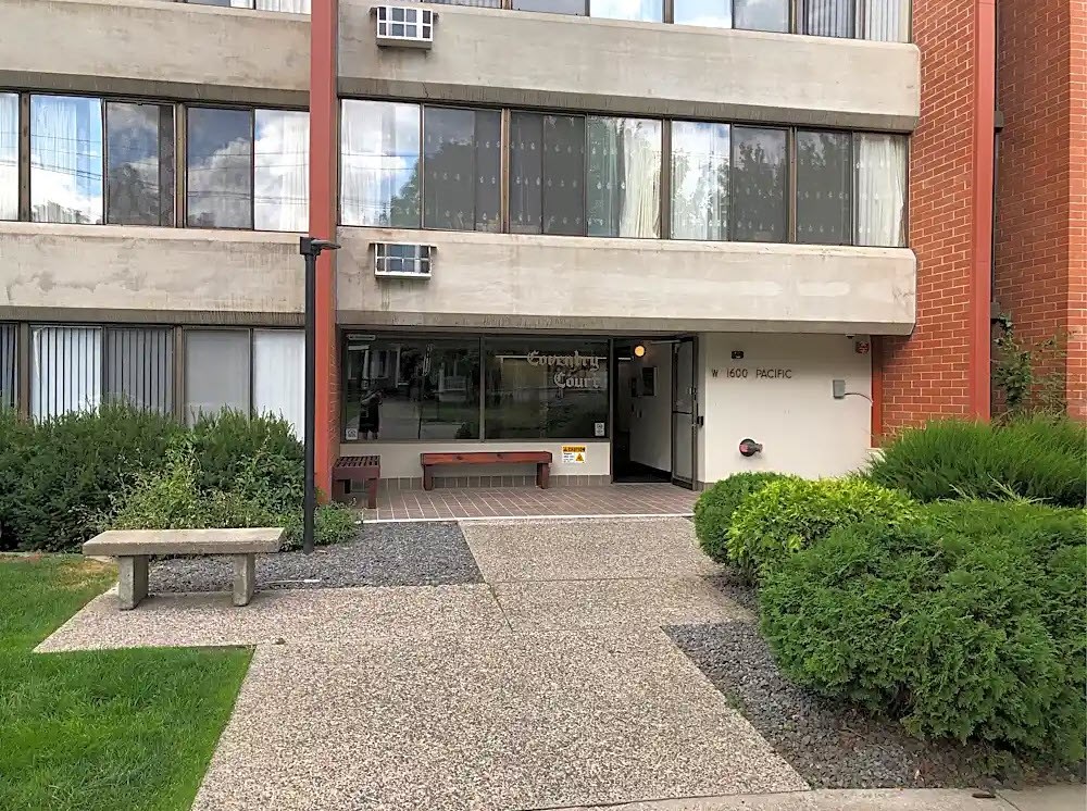 The image shows a building entrance with a sign that reads