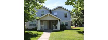 A two-story house with a front porch and a white door.