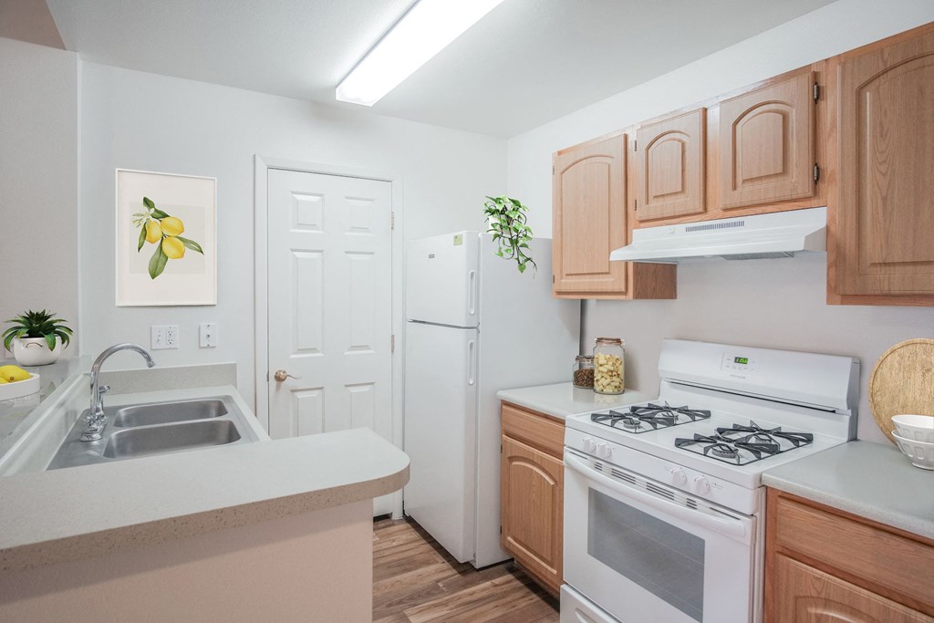 a kitchen with white appliances and wooden cabinets and a white refrigerator