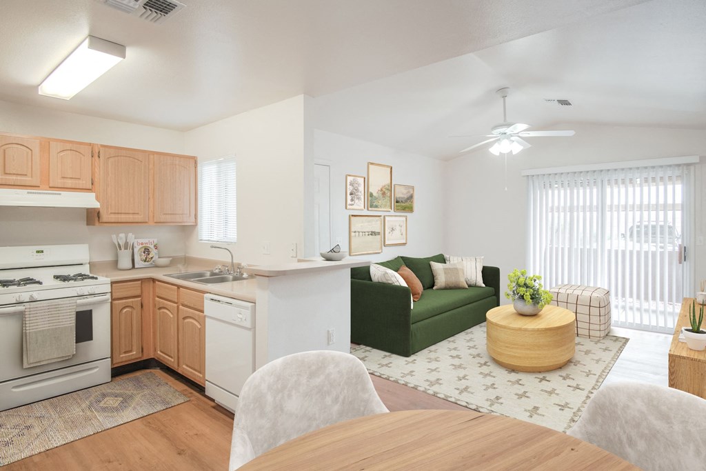 a living room and kitchen with a dining table and a green couch