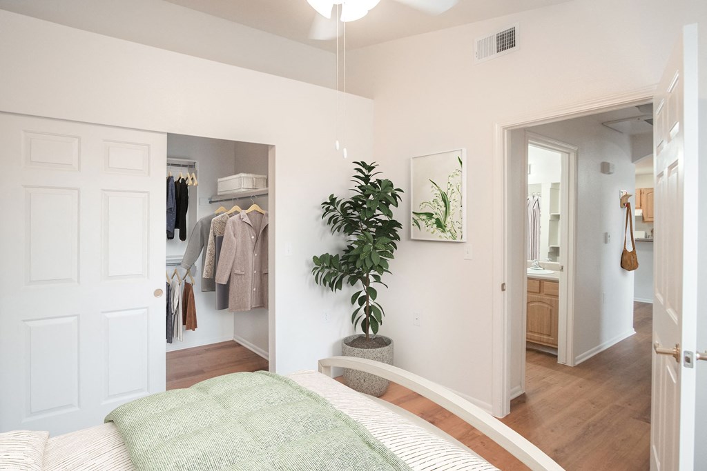 a bedroom with a bed and a closet with a plant