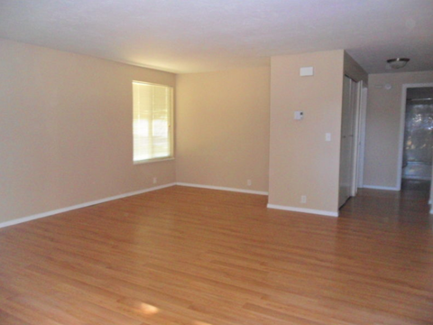 an empty living room with a hard wood floor