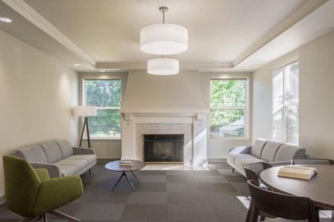 a living room with couches a table and a fireplace