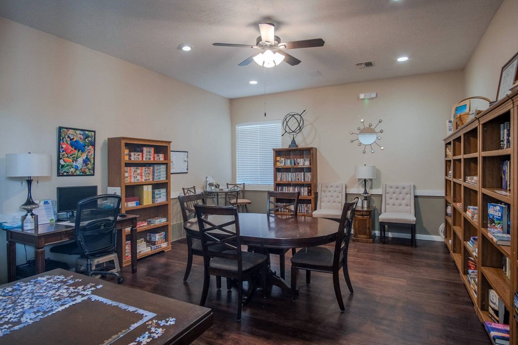a living room with a dining room table and bookshelves