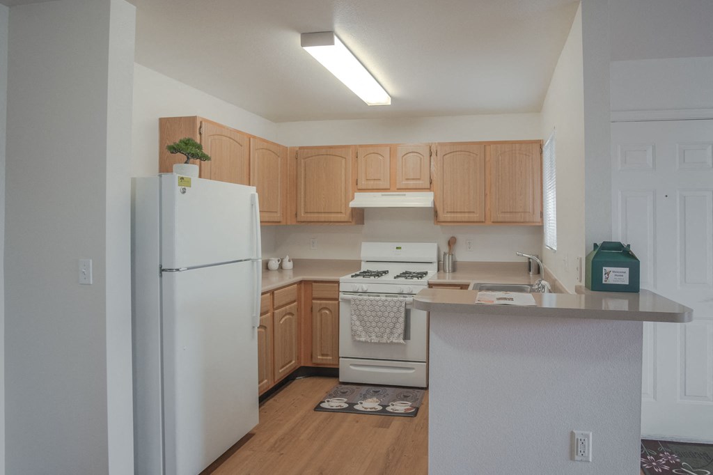 a kitchen with white appliances and wooden cabinets