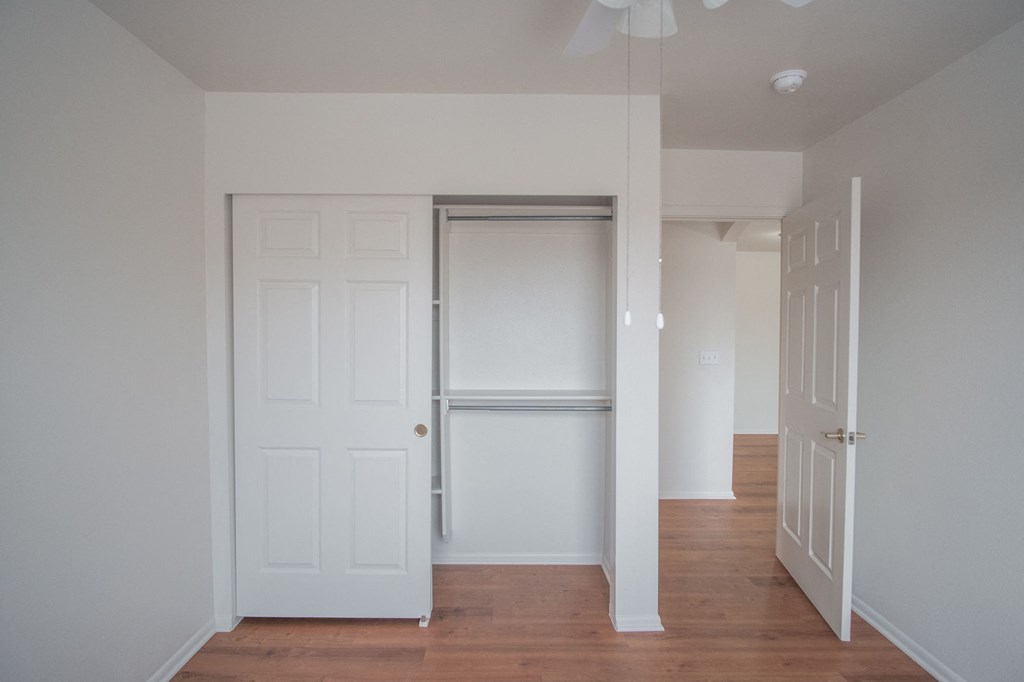 an empty hallway with white doors and a closet